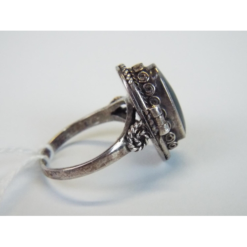 68 - Hallmarked silver poison ring with green hinged stone and scrolled shoulders, finger size P5