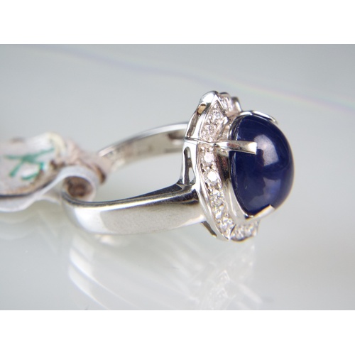 149 - Very large Cabochon Sapphire, set in 18ct White Gold ring surrounded by Diamonds.  Sapphire weight 4... 