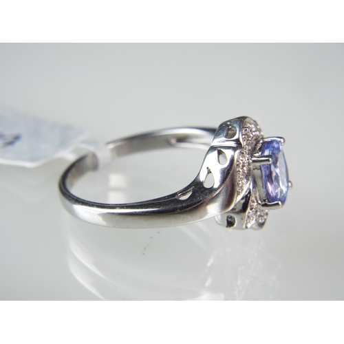 132 - 18ct White Gold Ring set with Oval Cut Tanzanite (6 x 5 mm) Multi Diamond surrounding.