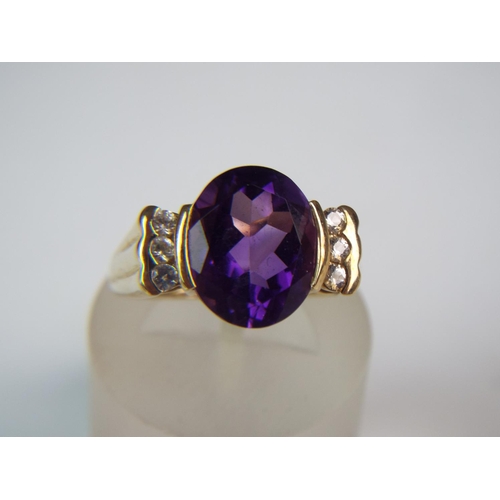 242 - 9ct Gold ring set with large Siberian Amethyst flanked by white Topaz stones.  Finger size 'O'  3.9g