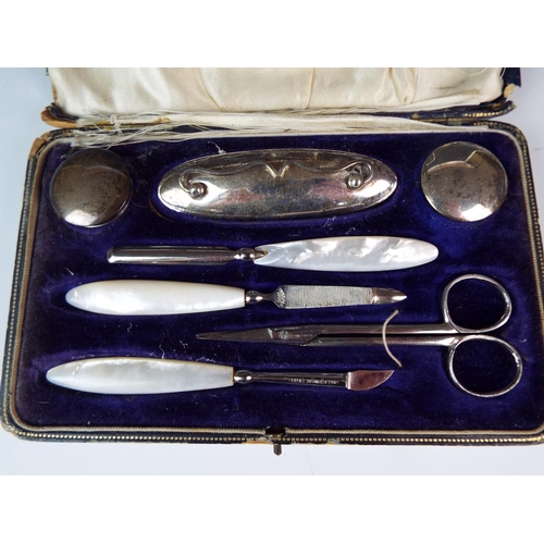 101 - Complete and boxed Silver manicure set inlaid with MOP. Birmingham 1919, Box with age related wear.