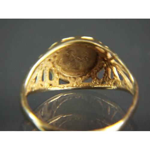 132 - 9ct Yellow gold ring with scrolled and pierced shoulders set with a gold Equador coin.  Finger size ... 