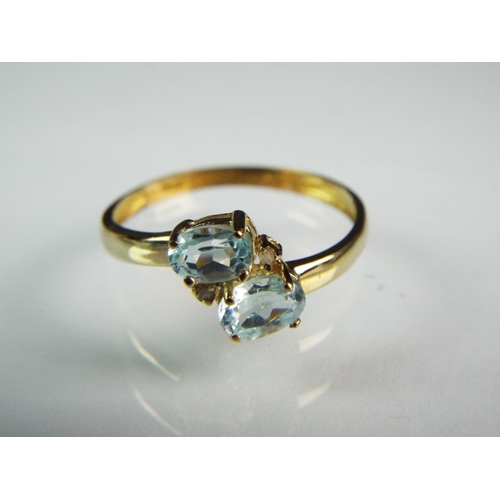 154 - 9ct Yellow gold ring set with two oval Aquamarines .  Finger size 'P'    1.1g