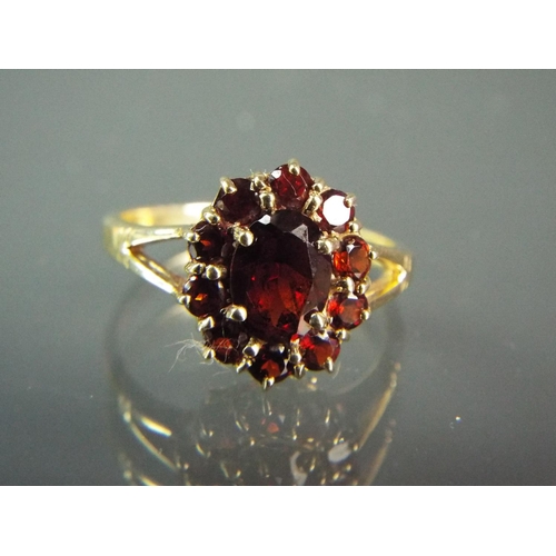 179 - 9ct Yellow gold ring set with Garnet in a Flower pattern. Finger size 'Q5'   3.2g