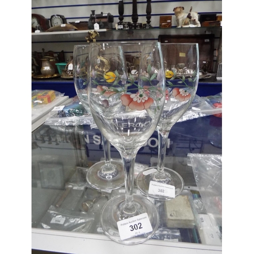 302 - Three pretty long stemmed glass hock glasses decortated with flowers