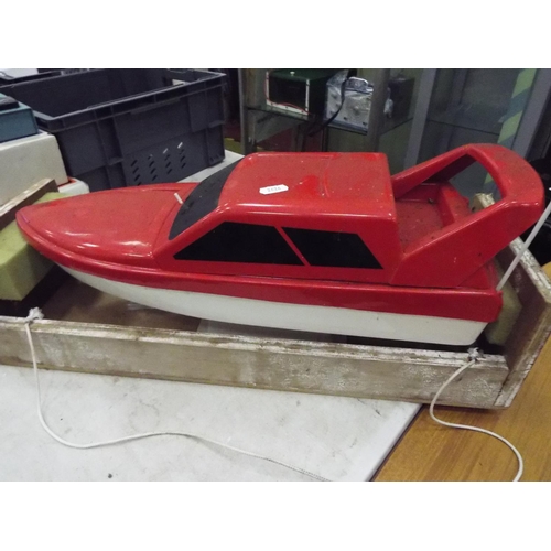 21 - Radio controlled plastic powerboat in wooden cradle. 20 inches long. Working condition unknown.