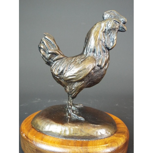 32 - Bronze figurine of a Cockerel raised on an oval wooden plinth. 5 inches tall overall. Signed to base... 