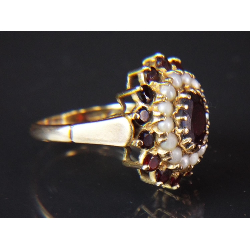 63 - 9ct Gold, Large Garnet set ring surrounded by a Halo of Pearls in turn surrounded by Garnets. Pierce... 