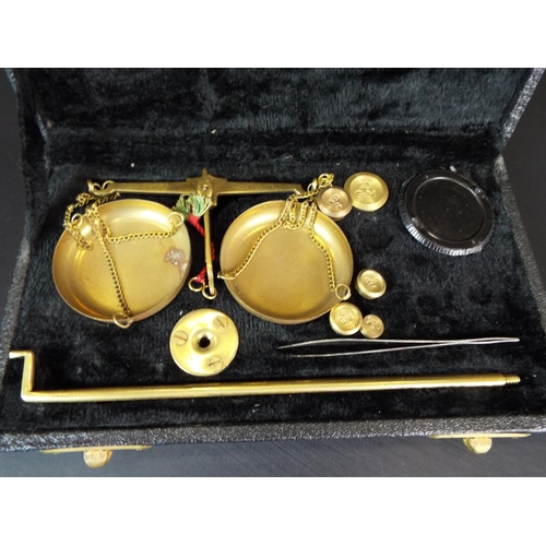 104 - Set of scentific scales and weights in velvet lined box.