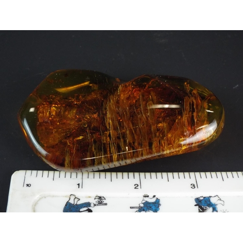 128 - Large piece of Baltic amber measuring 3.5 inches long by 2 inches wide. 72.9 grams