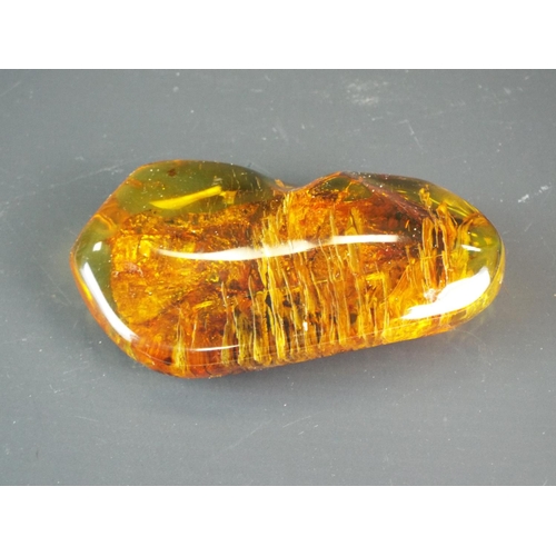 128 - Large piece of Baltic amber measuring 3.5 inches long by 2 inches wide. 72.9 grams