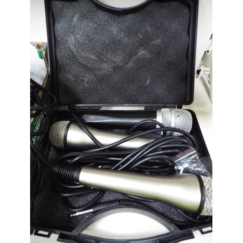 606 - Hard plastic case containing three microphones with jack plugs