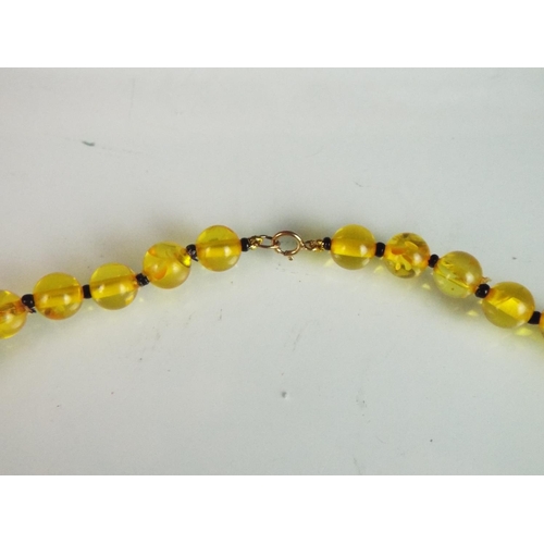 146 - 24 inch Amber bead necklace with a 9ct Yellow gold clasp. Each bead approx 6mm.