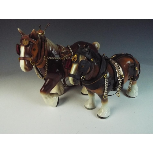 50 - Two ceramic shire horses with leather tack. Each measures approx 10 inches long.