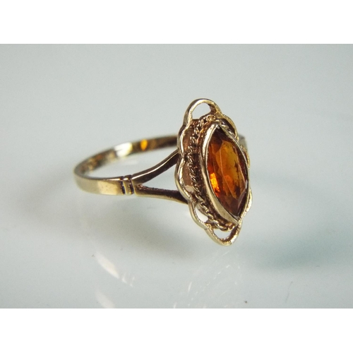 88 - 9ct ring set with orange citrene. Fancy decoration to shoulders and stone setting. 'Q'    2.2