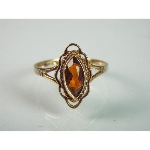 88 - 9ct ring set with orange citrene. Fancy decoration to shoulders and stone setting. 'Q'    2.2