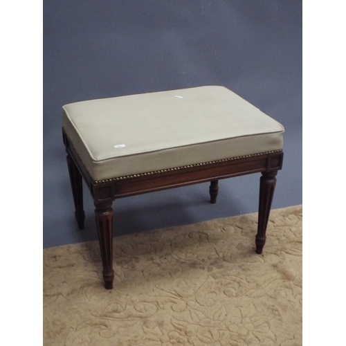 388 - Small cream leather topped footstool with carved fluted legs. 16 inches tall.