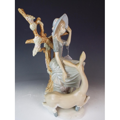 33 - Large Unmarked figurine in the style of Nao depicting a sitting lady with a deer. 14 inches tall.