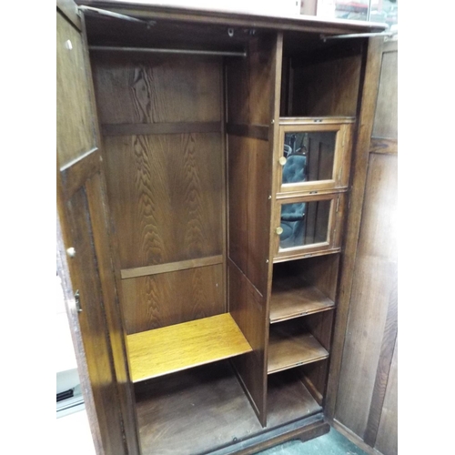 55 - Nicely made dark oak medium sized wardrobe decorated with panels and fluted columns. Exposed decorat... 