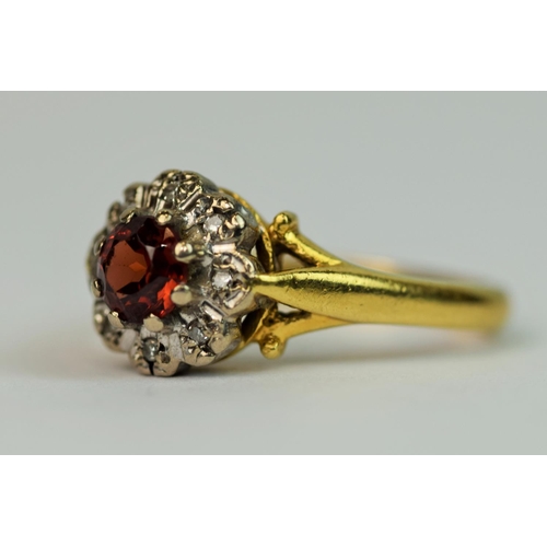 301 - 18ct Yellow Gold ring set with a large central Garnet with Diamond Surround. Finger size 'L'   4.4g