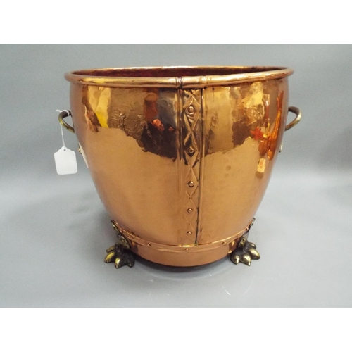 213 - Large hammered copper planter with 3 brass feet and brass handles. 13 inches tall 13inch diameter.