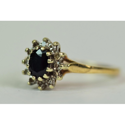 519 - 9ct Yellow & White Gold ring set with a central Oval Sapphire of 5 x 3mm with a halo of  12 small si... 