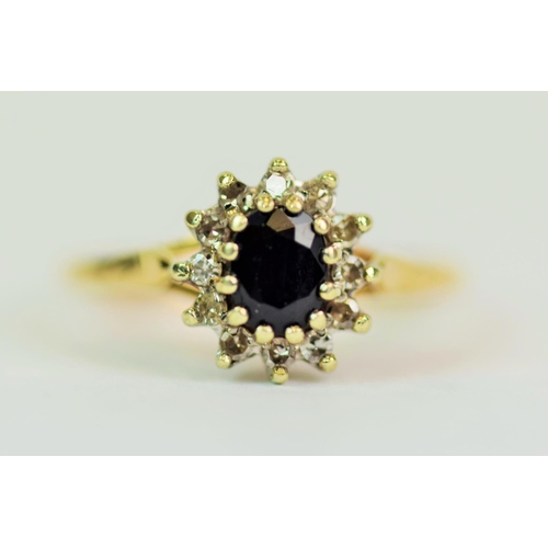 519 - 9ct Yellow & White Gold ring set with a central Oval Sapphire of 5 x 3mm with a halo of  12 small si... 