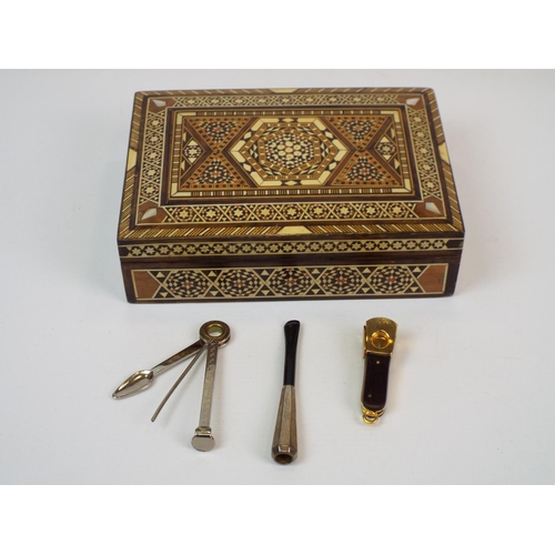 379 - Geometric inlaided cigar box complete with cigars, silver cheroot, cigar cutter etc.