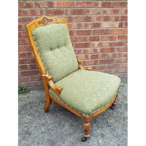 953 - light oak Nursing chair with carved decoration  Upholstered in a green material. Each on castors. Se... 