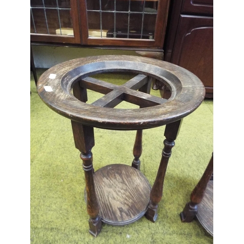 985 - Two dark oak circular topped Jardinaire stands. Each 19 inches tall. See photos.