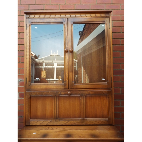 1033 - Ercol Cupboard with two doors and glazed doors above. Comes in two pieces for ease of movement. H:77... 