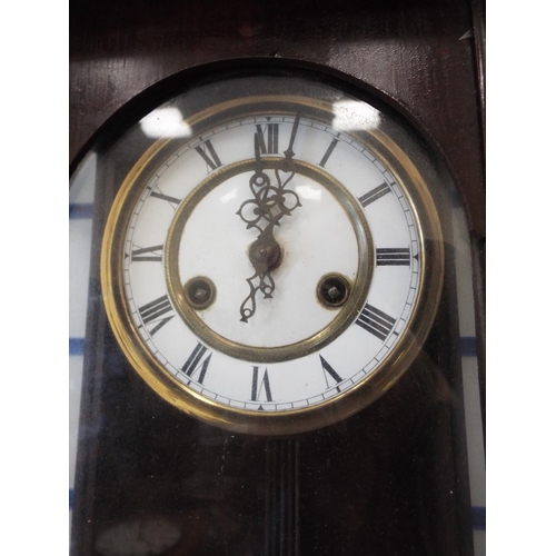 1103 - Dark wood wall clock with enamel face and pendulum. Working condition unknown.