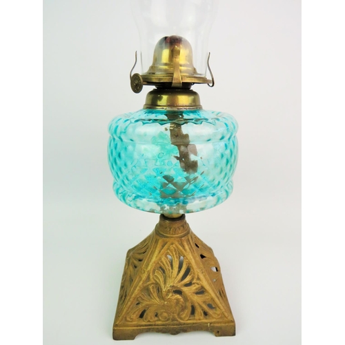 301 - Vintage oil lamp with Topaz coloured reservoir, scolled metal base, glass chimney. Approx 21 inches ... 