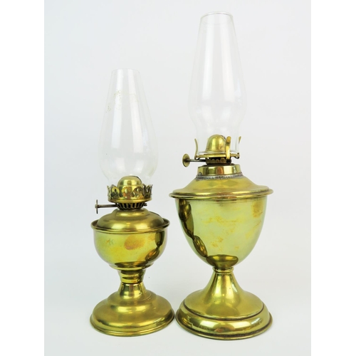 309 - Two vintage oil lamps with brass reservoirs. Both with glass chimneys, largest approx 10 inches tall... 