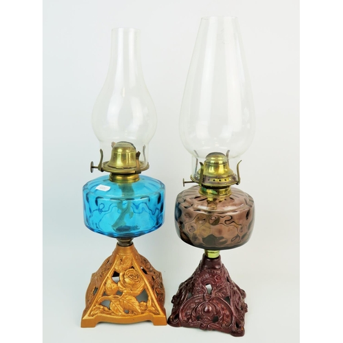 312 - Two very pretty antique oil lamps with pierced cast bases and coloured glass reservoirs, clear chimn... 