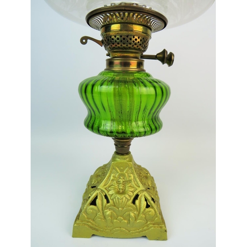 368 - British made antique oil lamp standing on pierced cast metal base, Emerald glass reservoir, glass ch... 