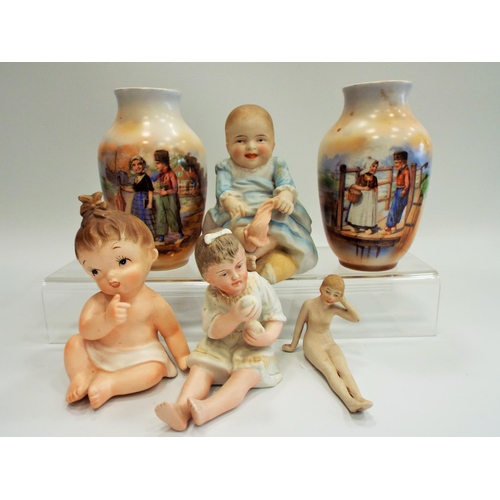 506 - A selection of bisque piano babies and a pair of dutch scene vases.