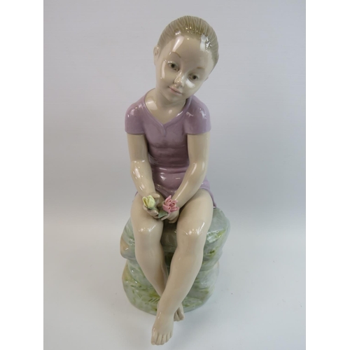 38 - Lladro/Nao figurine of a Girl sitting on a rock holding flowers. Figure number B-3-J measures approx... 