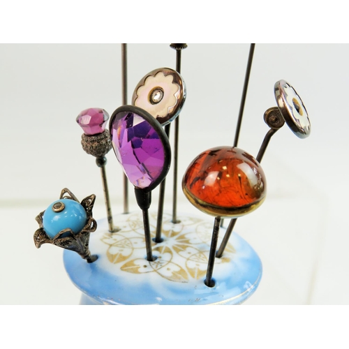 73 - Vintage Hatpin stand together with a collection of Nine hatpins, one of which has an Amber top. See ... 