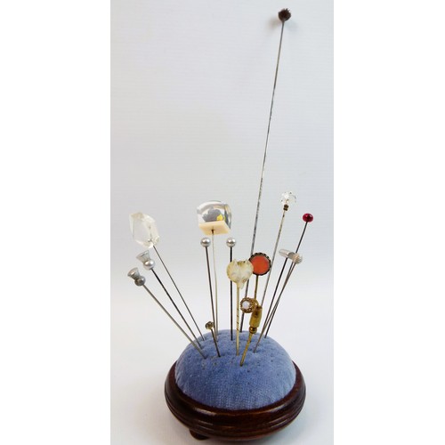 76 - Selection of vintage hat pins and a hat pin cushion.