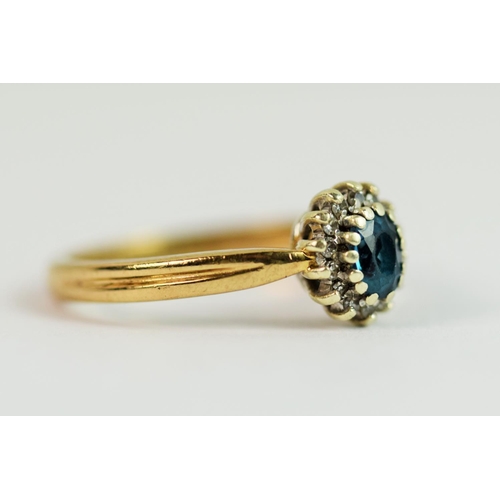 211 - 9ct Yellow gold ring set with an oval central topaz with Diamond halo.  Finger size  'O'   3.1g