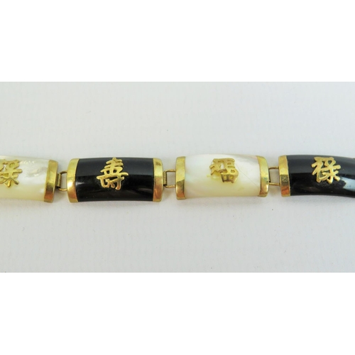 527 - Pretty oriental bracelet with 9ct yellow gold links and fasteners. Links of Mother of pearl and jet ... 