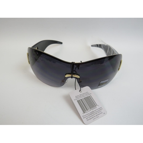 542 - A pair of seemingly new and unused designer sunglasses along with a pair of hinged lens reading glas... 