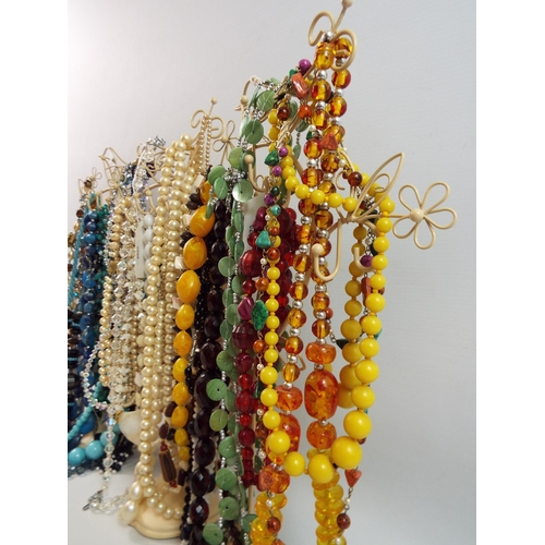 724 - Large quantity of vintage costume jewellery necklaces on stands.