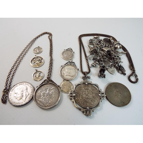 729 - Sterling silver mounted and unmounted coins, charm bracelets and pendants a total of 290grams of sil... 