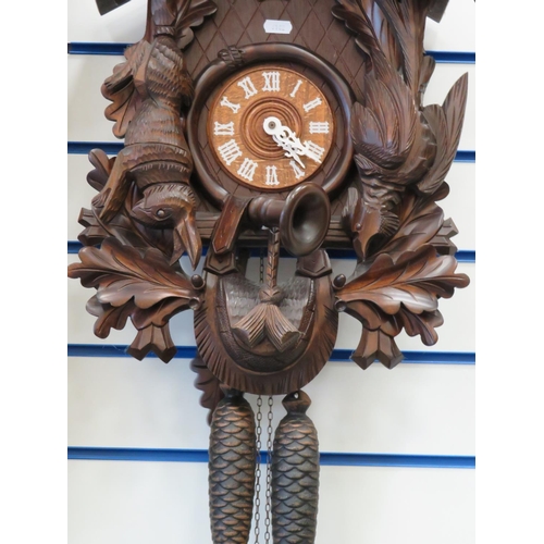 868 - Lovely black forest style Cuckoo Clock in a hunting theme showing carved game birds, Hare, Stag and ... 