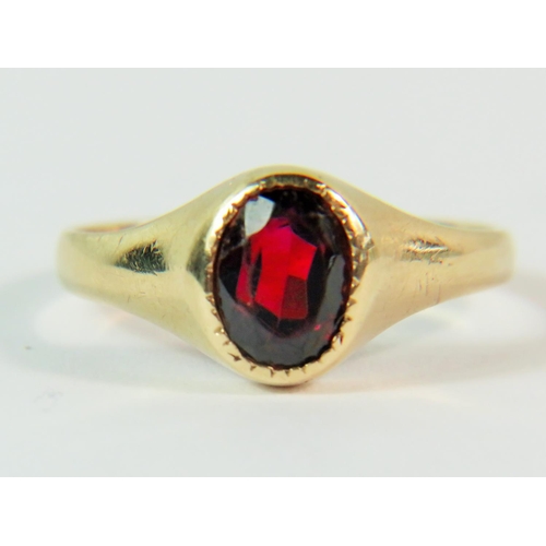 103 - 9ct Yellow Gold ring set with a dark oval Garnet. Finger size 'J'  1.8g. Clear hallmark for London 1... 