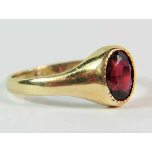 103 - 9ct Yellow Gold ring set with a dark oval Garnet. Finger size 'J'  1.8g. Clear hallmark for London 1... 