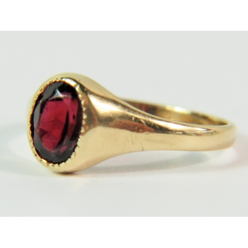 103 - 9ct Yellow Gold ring set with a dark oval Garnet. Finger size 'J'  1.8g. Clear hallmark for London 1... 