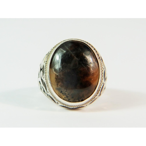 113 - 925 Gents silver ring set with a large Moss Agate with pierced decorative shoulder mounts. Finger si... 